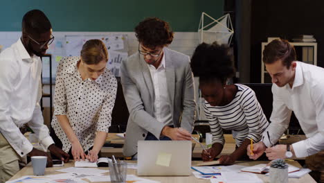 multiethnic business team analyzing documents, charts, financial reports and graphics in the office