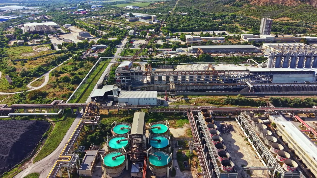 Sitio industrial con grandes instalaciones e infraestructura visto desde arriba en un día despejado en una zona desarrollada.
