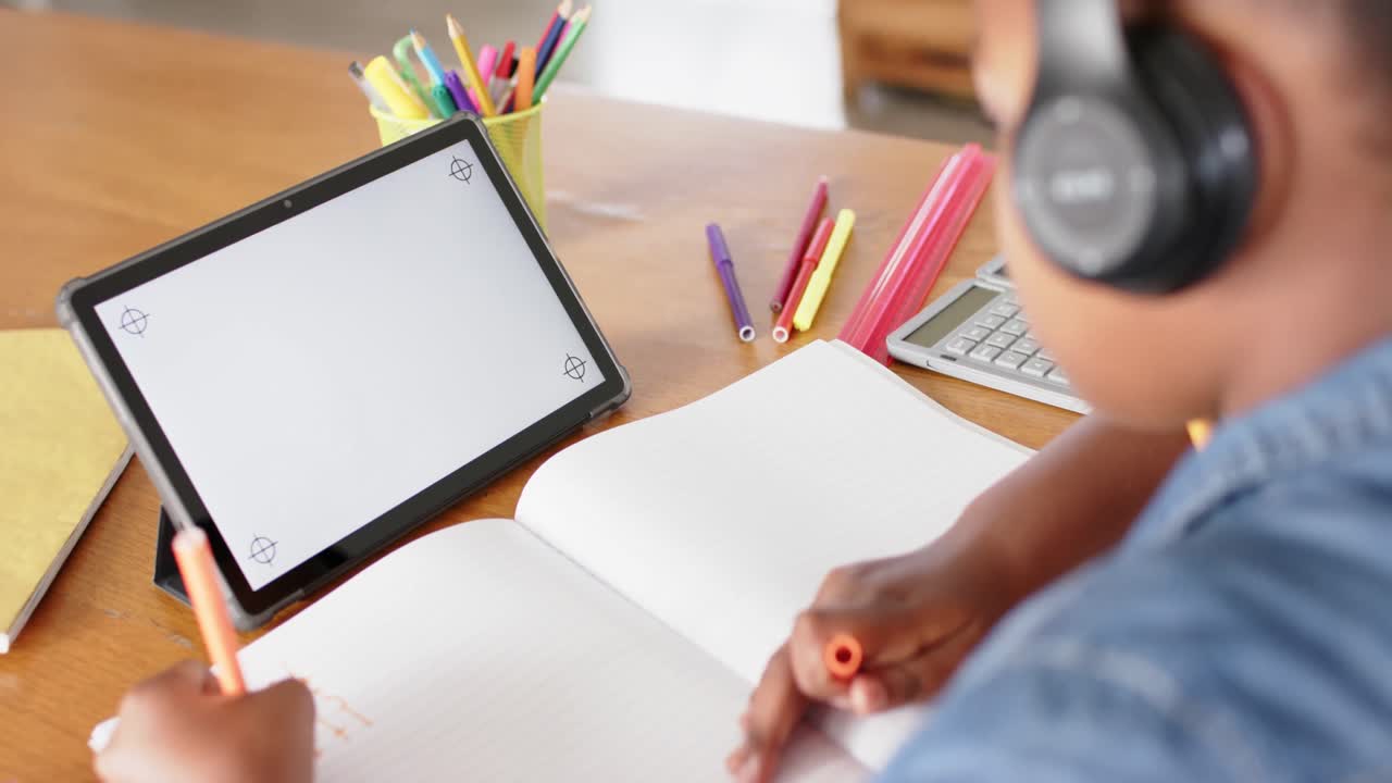 Unaltered african american girl using tablet with copy space for online lesson, in slow motion