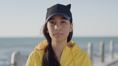 portrait calm young teenage girl looking at camera contemplative mixed race teenager on warm sunny seaside slow motion