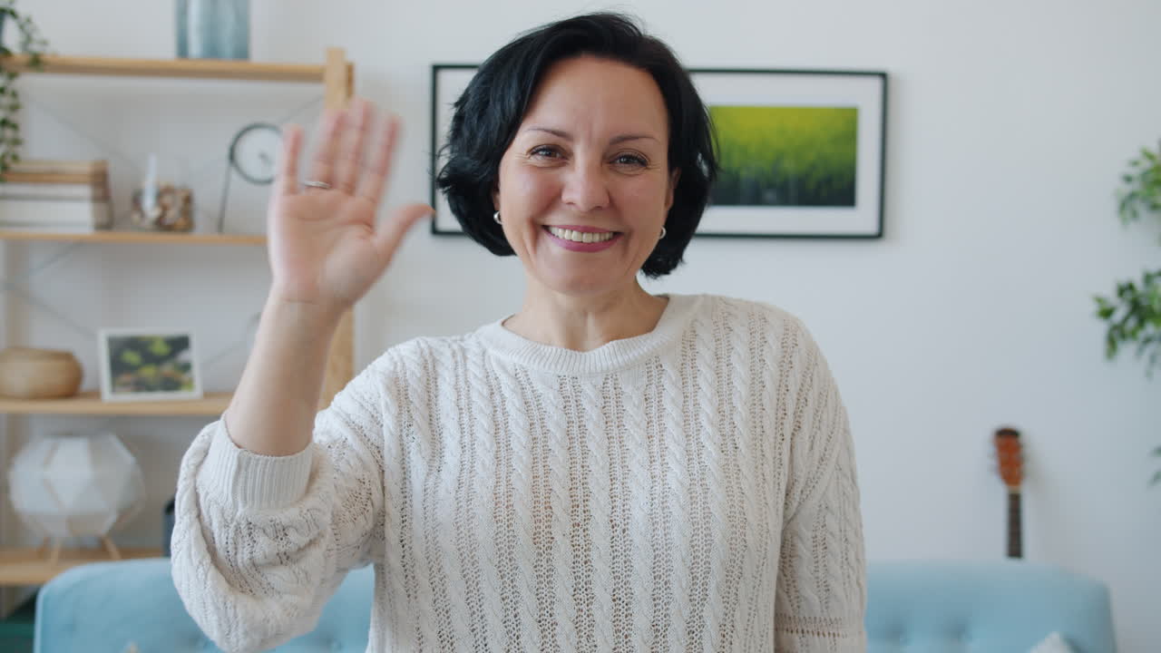Smiling woman waving during a video call