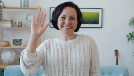 smiling woman waving during a video call