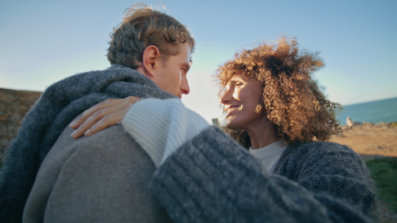Happy woman hugging boyfriend at sea beach closeup. Tender lovers embracing