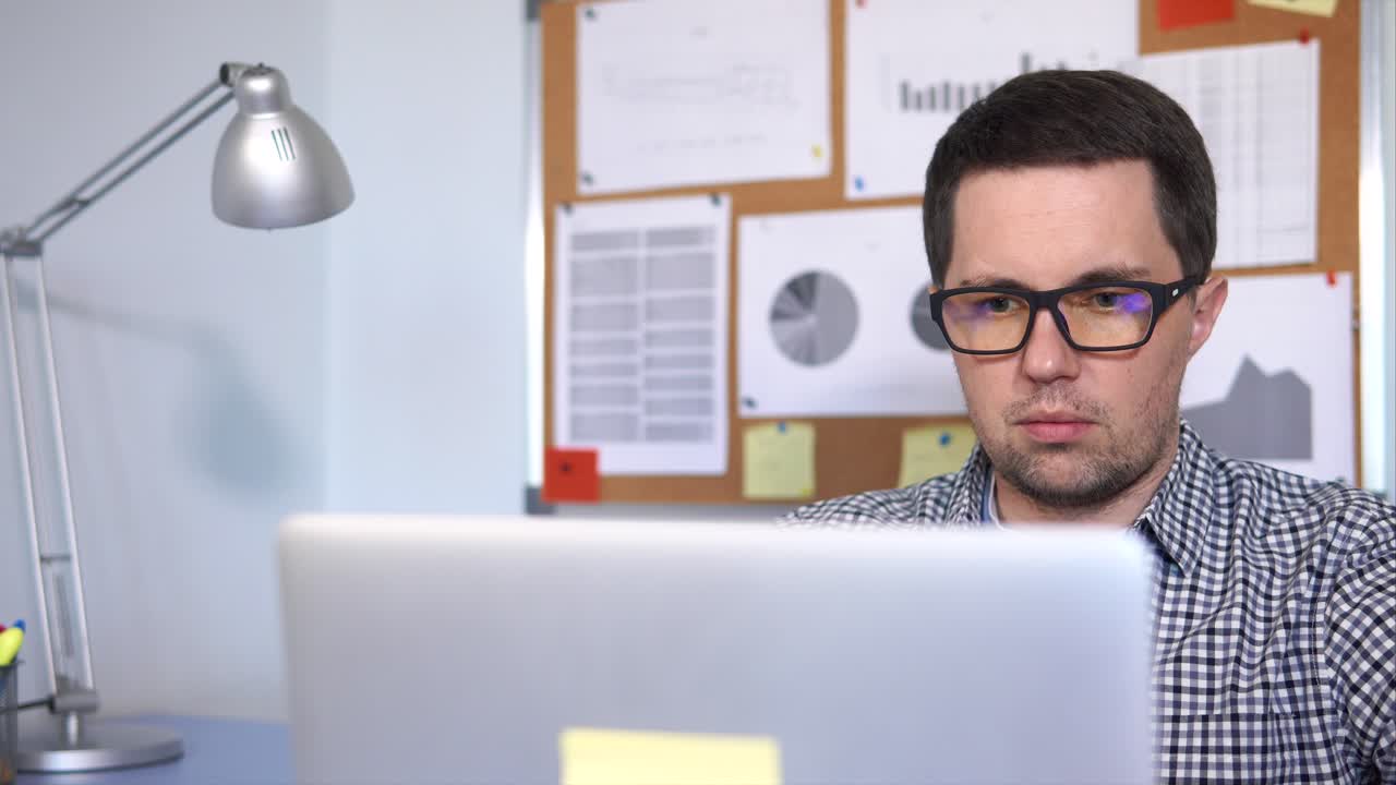 Hombre que trabaja en la computadora portátil en la oficina