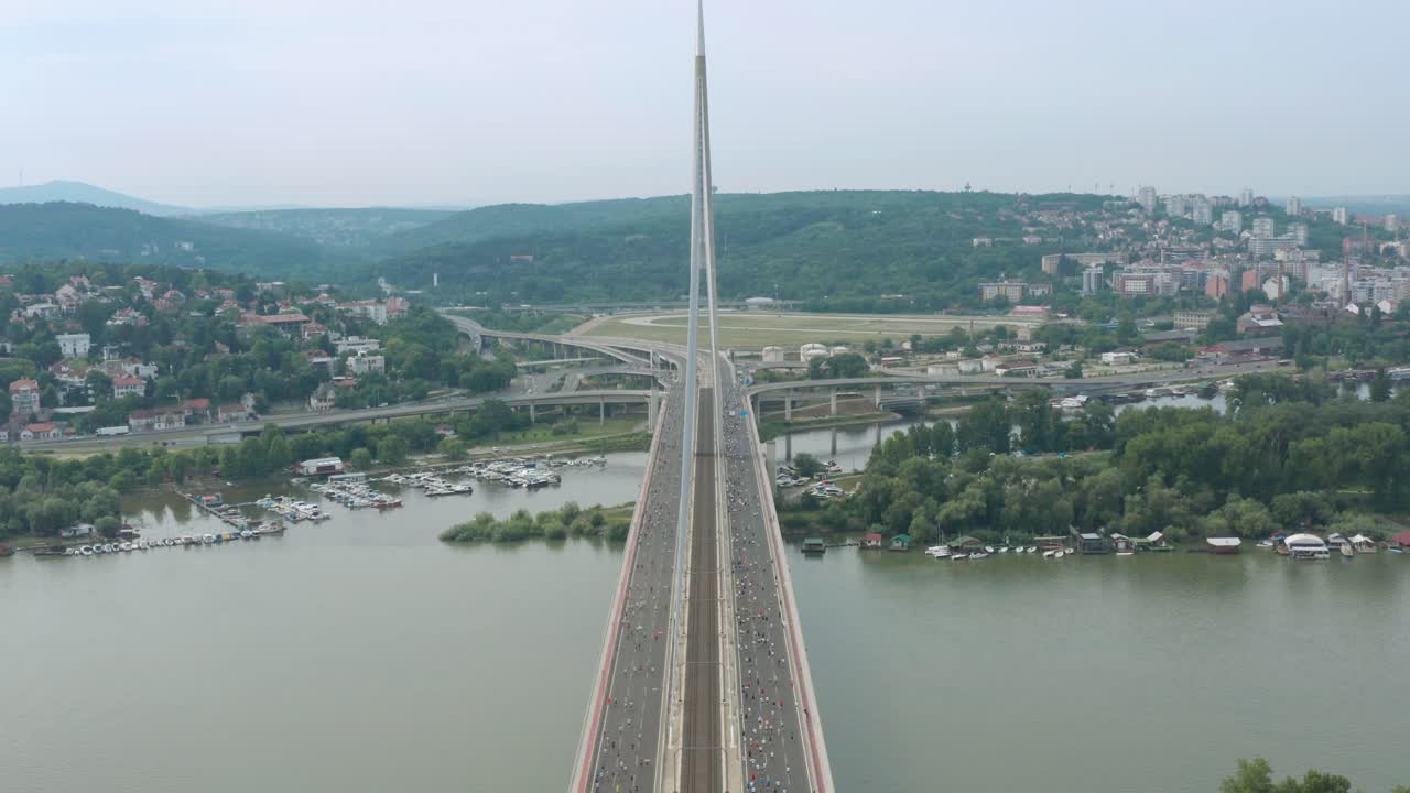 panorama de atletas cruzando el puente ada durante el maratón de belgrado