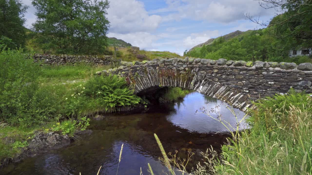 imágenes de video del atractivo puente de caballos de carga de watendlath sentado sobre el arroyo de watendlath, esta es la fuente de las cataratas de lodore, una atracción turística de la época victoriana