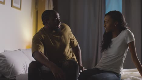 couple at home sitting on bed at night having argument 7