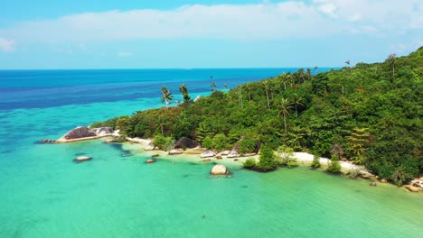 Paragliding-over-the-tropical-forest,-rocky-sea-shore-with-secluded-white-sandy-beaches