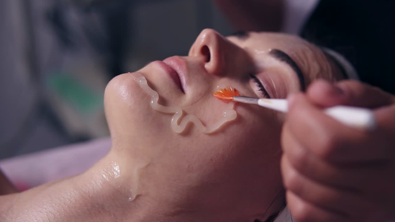 스파 살롱에서 젊은 여성을 위한 전문적인 카보시테라피. 전문적인 미용사가 있는 동안 젊은 여자가 소파에 누워 있습니다.