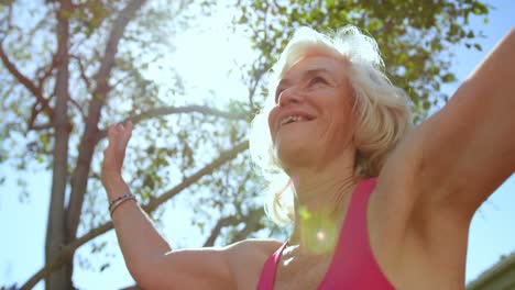 low angle view of active caucasian senior woman performing yoga in the garden of nursing home 4k