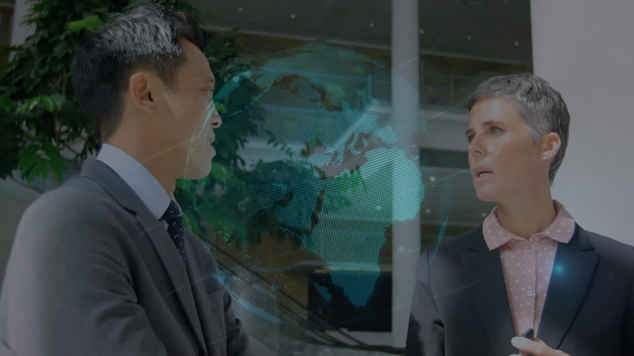 Discussing with digital globe animation overlay, two business professionals in office setting