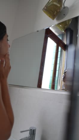 mujer aplicando cuidado de la piel en el baño