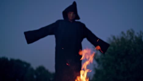 witch by the fire. witch by fire in night forest prepares magic potion
