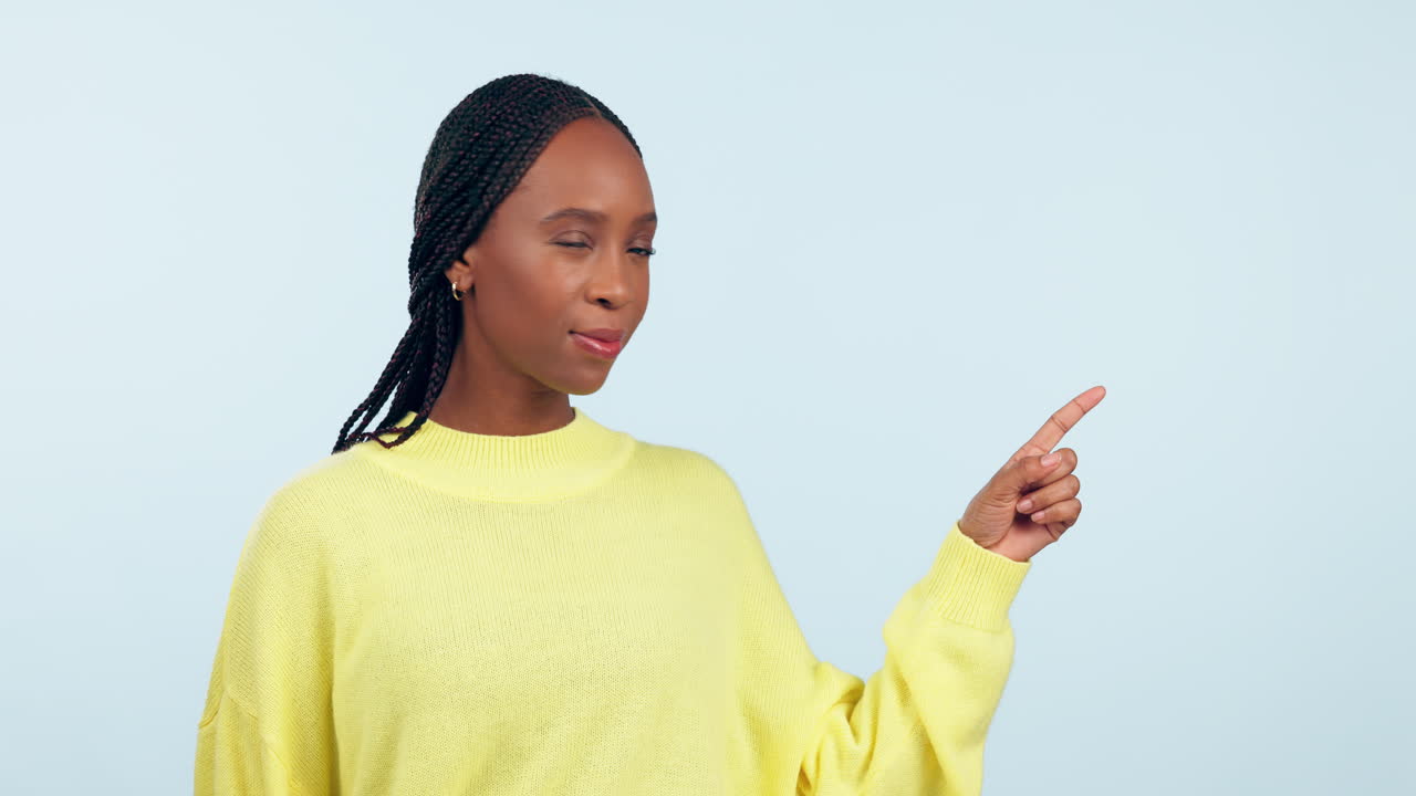Thumbs down, studio face and black woman point