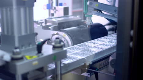 pharmaceutical packaging. worker hand put medical ampoules at production line