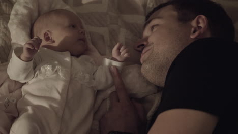 dad with beloved baby daughter lying on bed