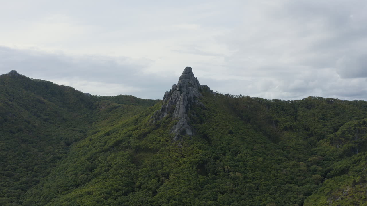 toma abierta de una enorme formación megalítica en la cima de una cordillera boscosa