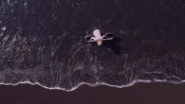 Salinai locali su spiaggia di sabbia nera a Klungkung, Bali