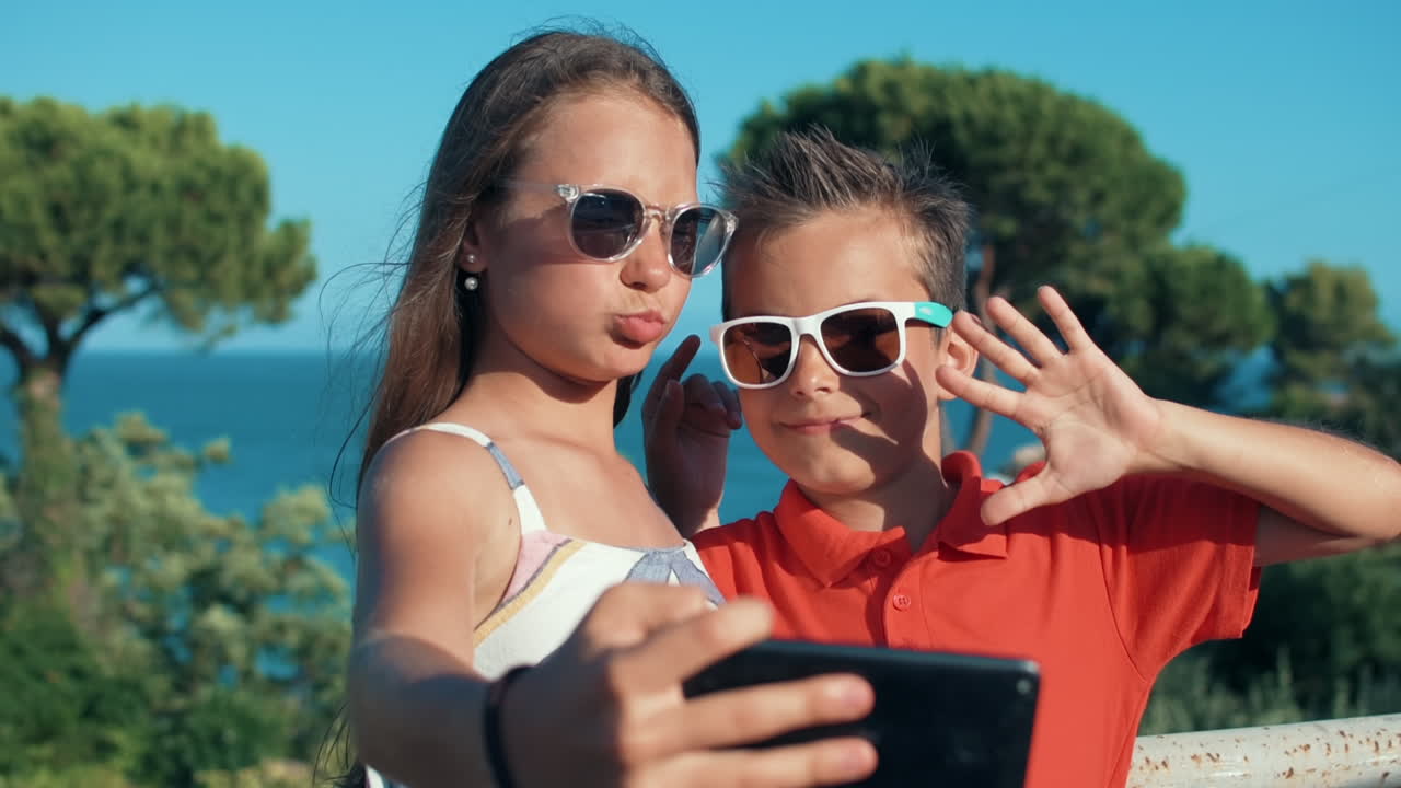 Joyful boy and girl grimacing to camera outdoor. Teenagers enjoying weekend.