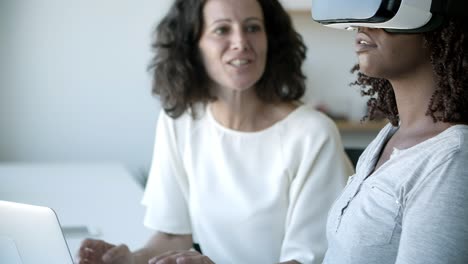 un primer plano de empleados alegres poniendo gafas de realidad virtual.