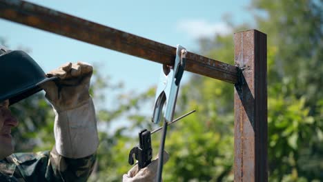 close view welder connects top parts of fence carcass