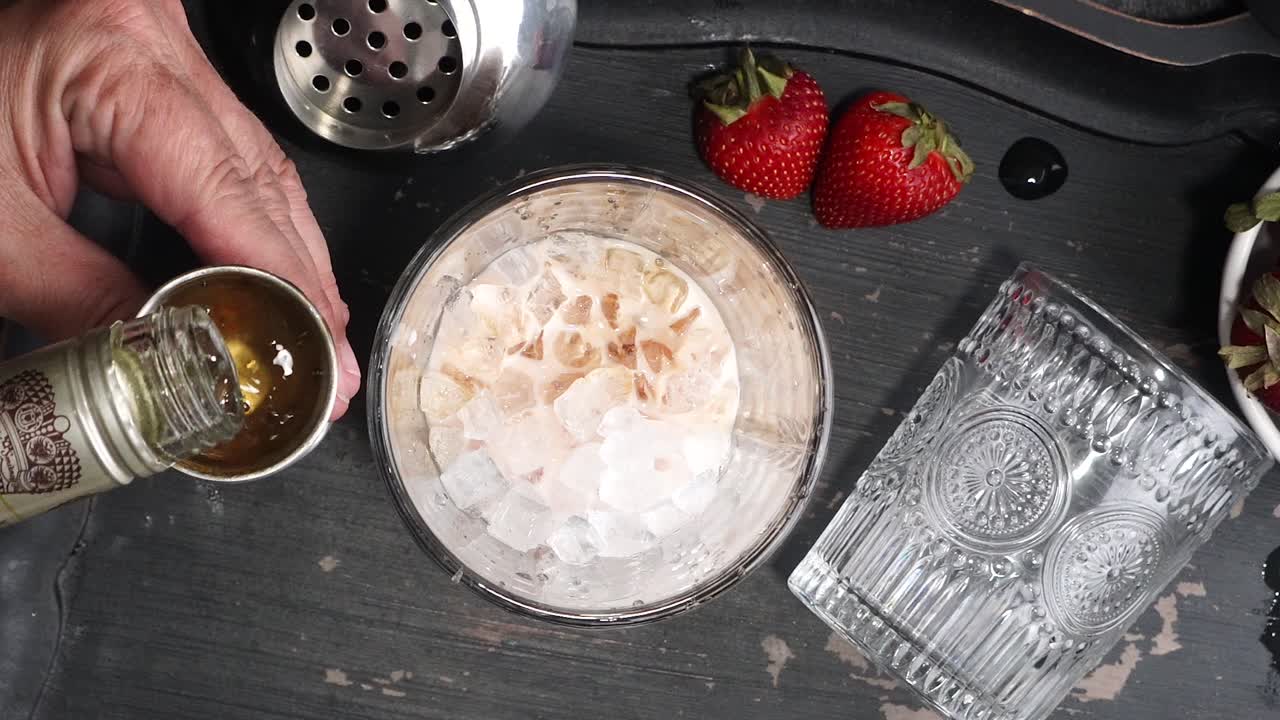 Pink cocktail drink with strawberry liqueur, vanilla vodka and cream. Party drink with strawberries. Fruit cocktail with fresh strawberries as a garnish. Cold and refreshing adult drink.