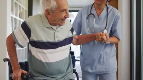 animación de una feliz médica biracial que cuida a un anciano caucásico