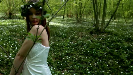 the goddess of the forest in a white beautiful dress welcomes spring and white flowers.