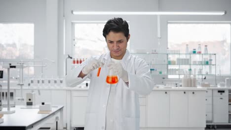 Happy-Indian-scientist-mixing-chemicals-for-experiment