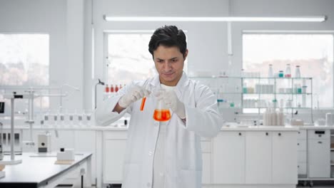 científico indio feliz mezclando productos químicos para el experimento