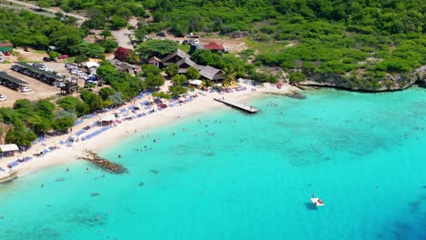 High-angle-drone-view-of-Playa-Porto-Mari-with-swimmers-and-sunbathers