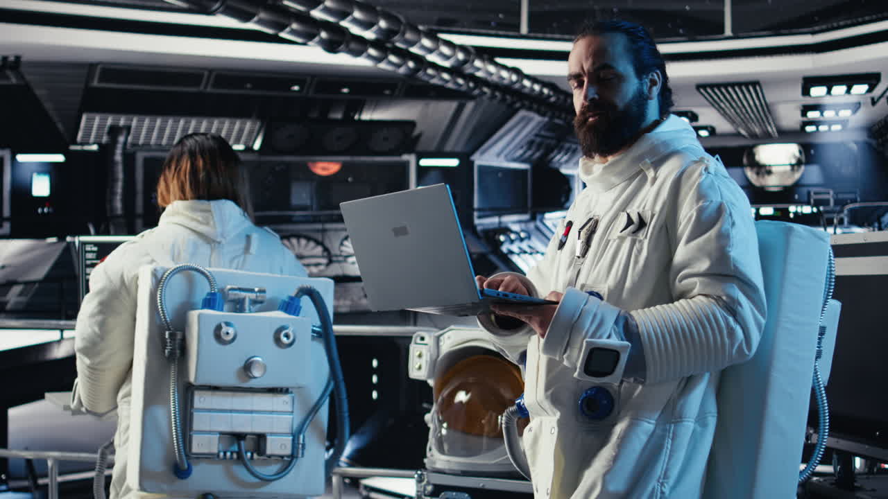 Astronaut reviewing onboard analytics on laptop before stepping out of station