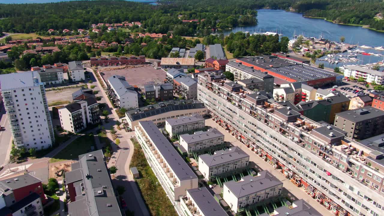 Vista aerea di edifici residenziali nuovi e vecchi con cantiere edile e porto turistico vicino al lago a Gustavsberg