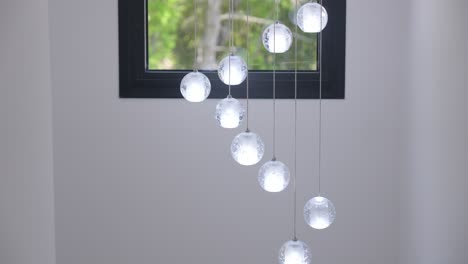 diseño de luminaria de techo minimalista que consiste en cuerdas y bolas de vidrio colgantes con bombillas