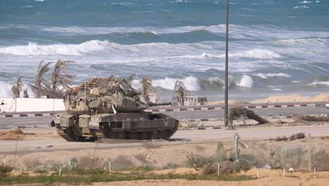 an israeli merkava mark iv barak tank moving slowly along the coastline