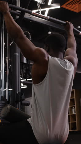 hombre realizando pull-ups en un gimnasio