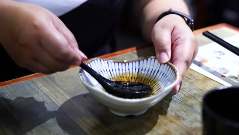 persona agitando la salsa en un cuenco pequeño