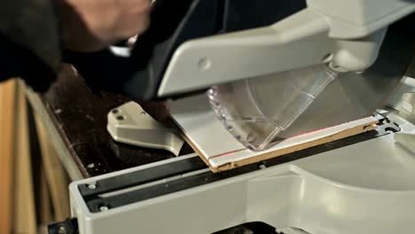 primer plano de la mano de un hombre trabajando en una máquina con una sierra circular