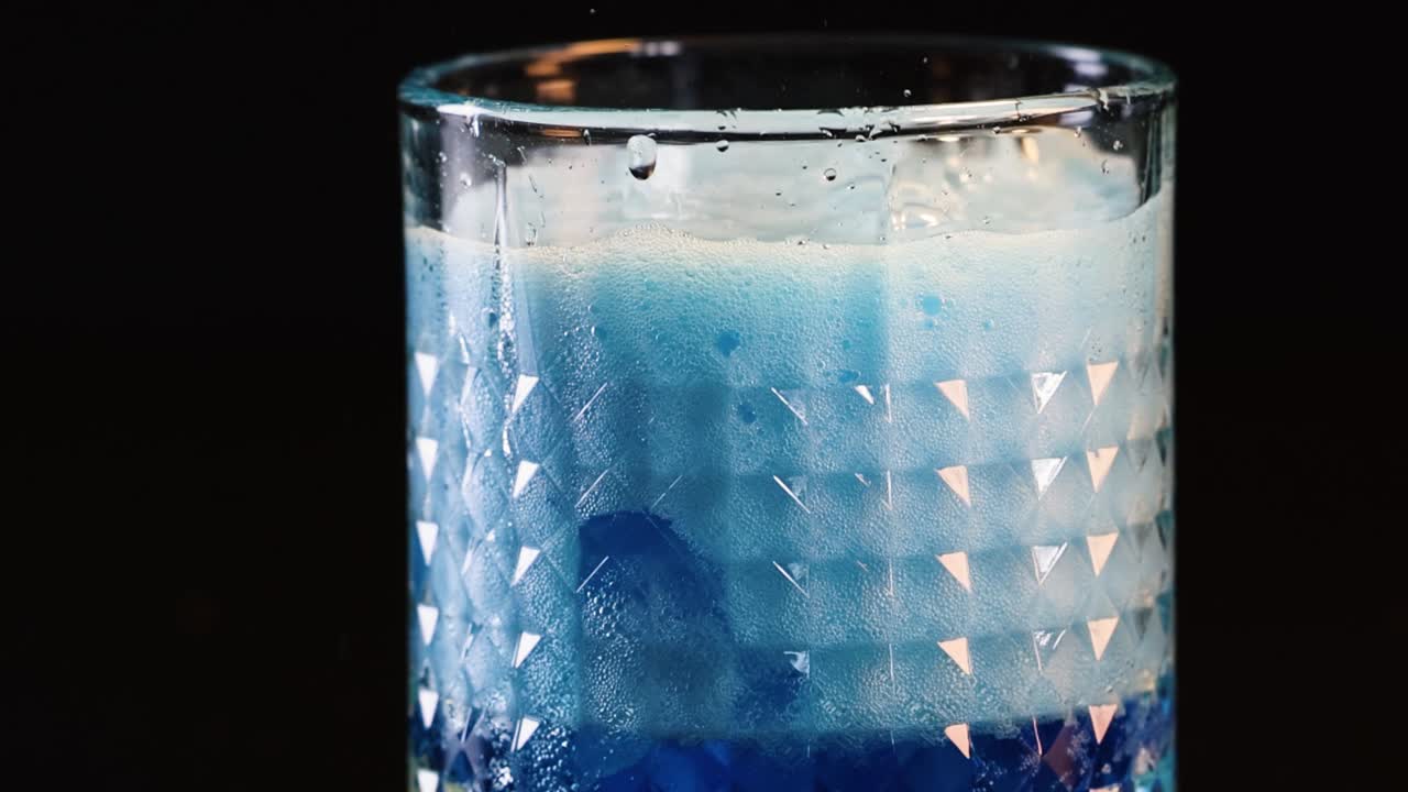 質感のあるクリスタルグラスを満たす鮮やかな青いソーダ、濃厚な白い泡と気泡が立ち上る。