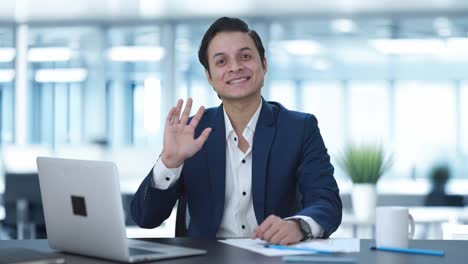 happy indian businessman waving hi to the camera