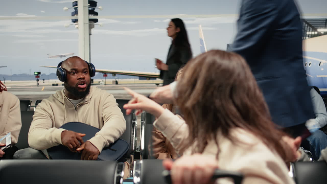 Multiethnic group of friends in airport chatting, waiting at departure gate