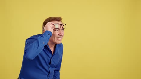man in blue shirt adjusting glasses and straining to see