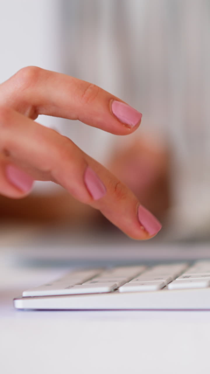 Woman hand makes calculations typing on modern white numeric keyword and laptop against blurred background in office slow motion extreme closeup