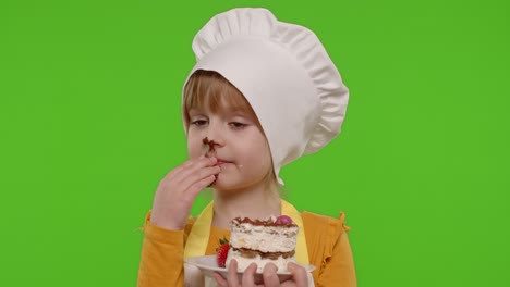 Child-girl-kid-dressed-as-professional-cook-chef-showing-eating-tasty-handmade-strawberry-cake