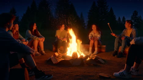 friends roasting marshmallows around a campfire at night