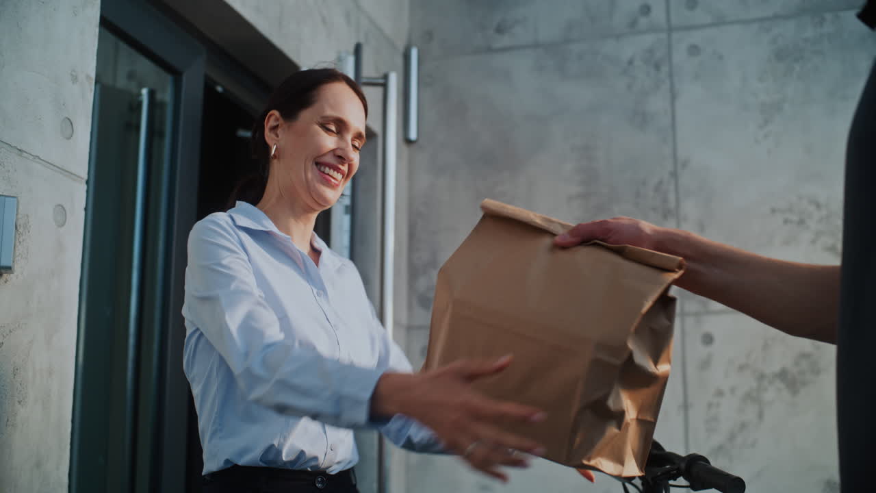 Happy woman receives a food or package delivery at her doorstep