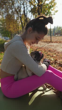 girl cuddling a puppy in the park