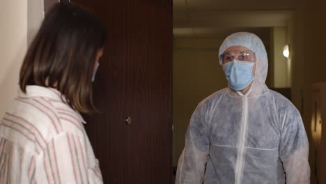 woman and a man wearing medical gear with a sign that says 'safe your life! get vaccinated'