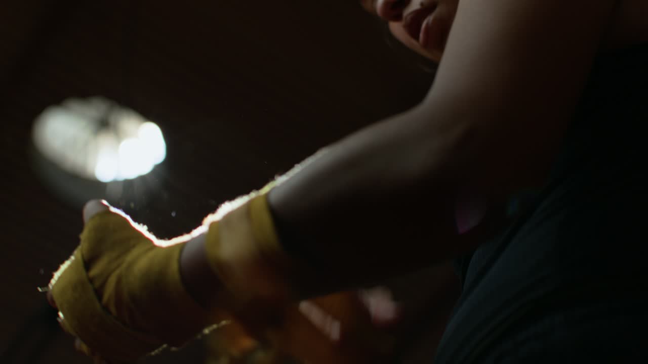 Female Athlete Wrapping Hands for Boxing Training