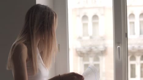 Slender-girl-cleaning-window-with-rag-while-doing-housekeep-work-at-home